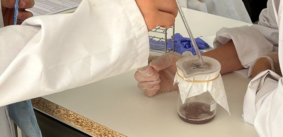 Una pipeta sobre un vaso con la mezcla de fresa filtrada