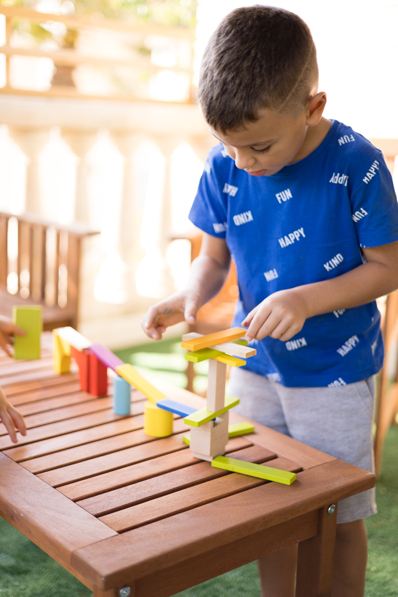 Un niño construye con piezas de madera de colores